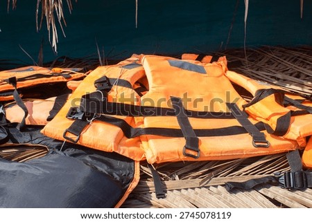 Stack of Orange Life Jackets Placed Inside a Boat