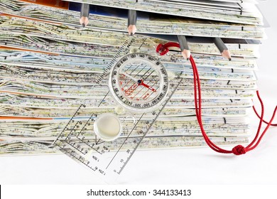 Stack Of Ordnance Survey Maps Along With A Compass And 4 Pencils 