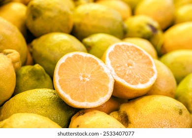 Stack of organic lemons with one cut in half at a food market stall in Valencia Spain