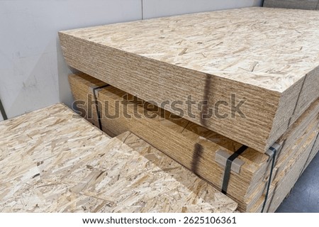 Stack of OSB panels in a hardware store, close-up. Materials for home and building repair and construction