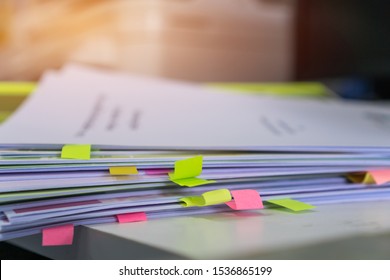 Stack of overwork of document report with post-it in business busy concept: Piles of paper files with postit on paperwork in overload at modern office