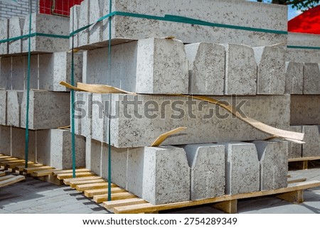 Stack of packed border stones for road on wooden pallet at building site.