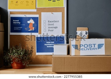 Stack of packed boxes with clothes or other humanitarian help for people in need and noticeboard with information about donation center