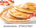 Stack of pancakes with butter and maple syrup breakfast plate
