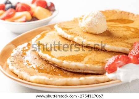 Stack of pancakes with butter and maple syrup breakfast plate