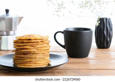 Stack Of Pancakes, Dark Mug And Coffee Pot On Wooden Table. Side View Selective Focus