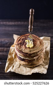 Stack of pancakes with fork over dark rustic wooden background close up