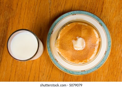 Stack of pancakes with glass of milk