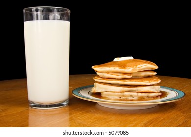 Stack of pancakes with glass of milk
