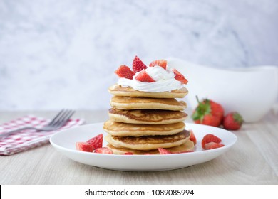 Stack Of Pancakes With Honey And Strawberry And Whip Cream On Top In Plate On White Table, Delicious Dessert For Breakfast.