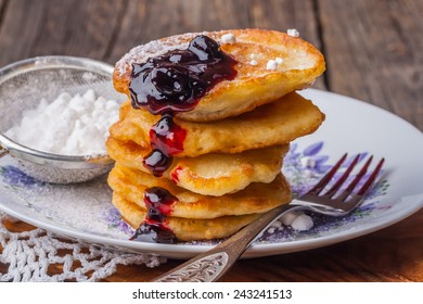 Stack of pancakes with jam and sugar