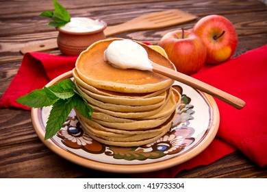 Stack of pancakes with mint and sour cream 
