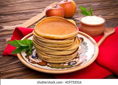 Stack of pancakes with mint and sour cream 
