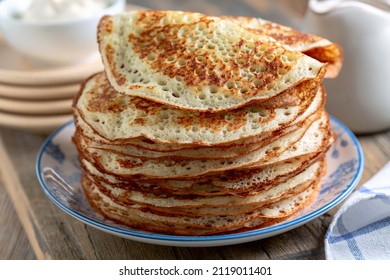 Stack of pancakes on a plate. Homemade pancakes, delicious food. Yeast pancakes are a traditional dish for the Russian Pancake week (Maslenitsa). Selective focus.