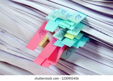Stack of paper with colored bookmarks or stickers. Old big data. Archive or bureaucracy sign.