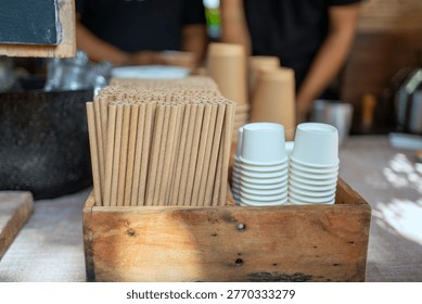 Stack of paper cups and biodegradable paper straws at cafe counter. Eco friendly, zero waste, and sustainable lifestyle concept.
