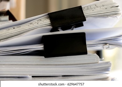 Stack of paper document files drawing architectural and construction sheet clipping with black paper clip.
