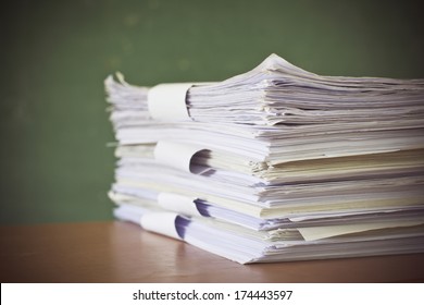 Stack Of Paper On Blackboard