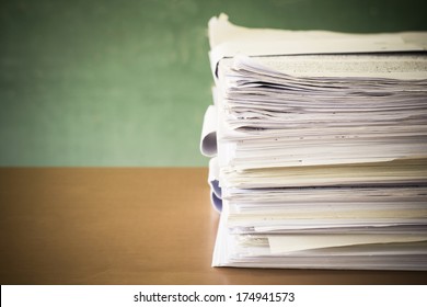 Stack Of Paper On Blackboard