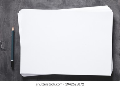 Stack of paper sheet and pencil with empty pages on abstract table background. Creative idea concept