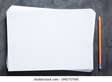 Stack of paper sheet and pencil with empty pages on abstract table background. Creative idea concept