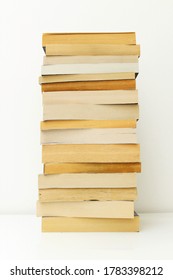 Stack of paperback books against white background with only the pages showing.