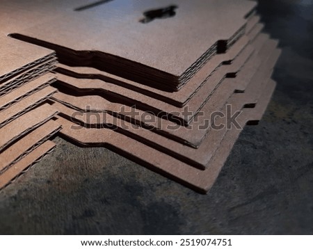 A stack of paperboard on a cement floor.