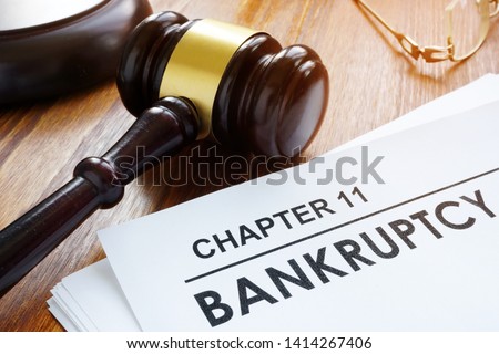 Stack of papers about chapter 11 bankruptcy and glasses.