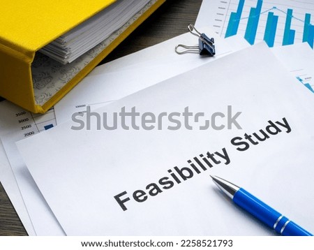Stack of papers with feasibility study and folder.