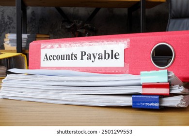 Stack of papers and folder labeled accounts payable. Financial management and accounting tasks.