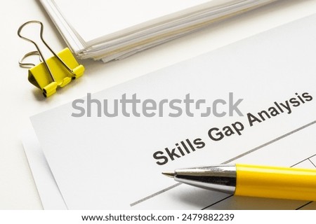 Stack of papers with skills gap analysis.