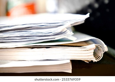 a stack of papers and a spiral notebook on a table