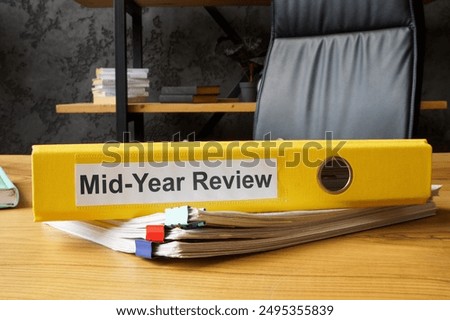 Stack of papers and yellow folder with mid-year review.