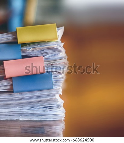Stack of paperwork on working desk with blurred focus background, business and education background