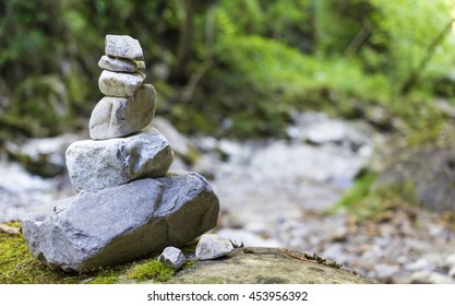 Stack of pebble stones by a stream in a forest
