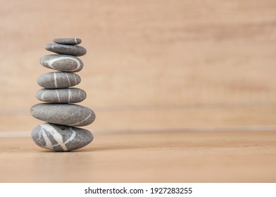 Stack of pebble stones on a wooden surface. Concept zen, spa, relax.