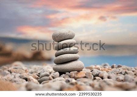Stack of pebble stones with sea sunset on the background