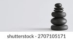 Stack of pebbles on grey background with space for text. Zen concept