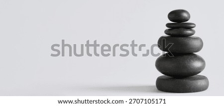 Stack of pebbles on grey background with space for text. Zen concept
