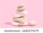 Stack of pebbles on pink background. Zen concept