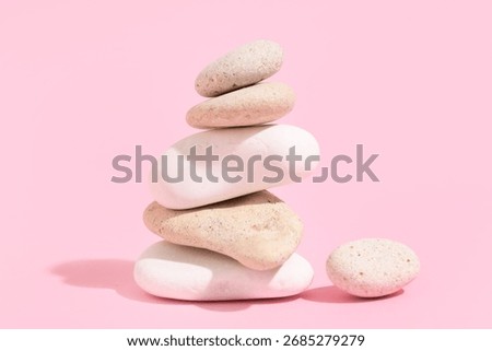 Stack of pebbles on pink background. Zen concept