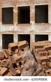 Stack of perforated red bricks covered polyethylene