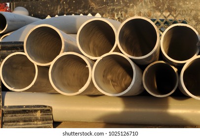 Stack Pf PVC Conduit Pipes, End View On Back Of Truck Bed. Close Up Pipe In Golden Sunlight.