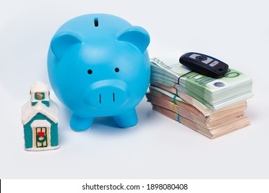 Stack pile of european money, Euro cash currency with a car key on it, a piggy bank next to it and a home on it isolated on white background. Savings for a new home, car. Real estate property mortgage - Powered by Shutterstock