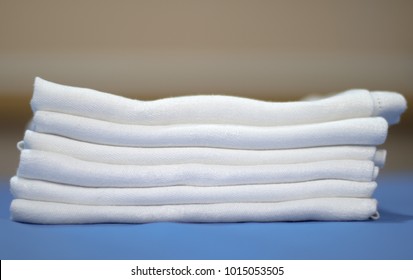 Stack Or Pile Of Folded Clothes, White Cloth Napkins Perfectly Ironed And Folded On Top Of Professional Iron Board With Creamy Background, Selective Focus, Laundry, Retail Or Textile Business