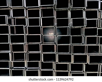 Stack pile of rectangle or sqaure industrial aluminum tubes in cross section view with light at the far end represent concept of light of hope, guidance light, dark path to target