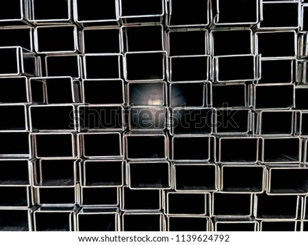 Stack pile of rectangle or sqaure industrial aluminum tubes in cross section view with light at the far end represent concept of light of hope, guidance light, dark path to target