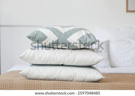 Stack of pillows on bed in light bedroom, closeup