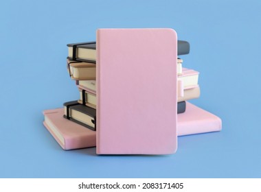 Stack of pink and grey hardcover notebooks on light blue closeup. Textbook mockup, planner cover with place fot text. Educational, business and organizing concept