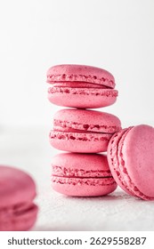 Stack of pink Macarons on white textured background isolated. Vertical